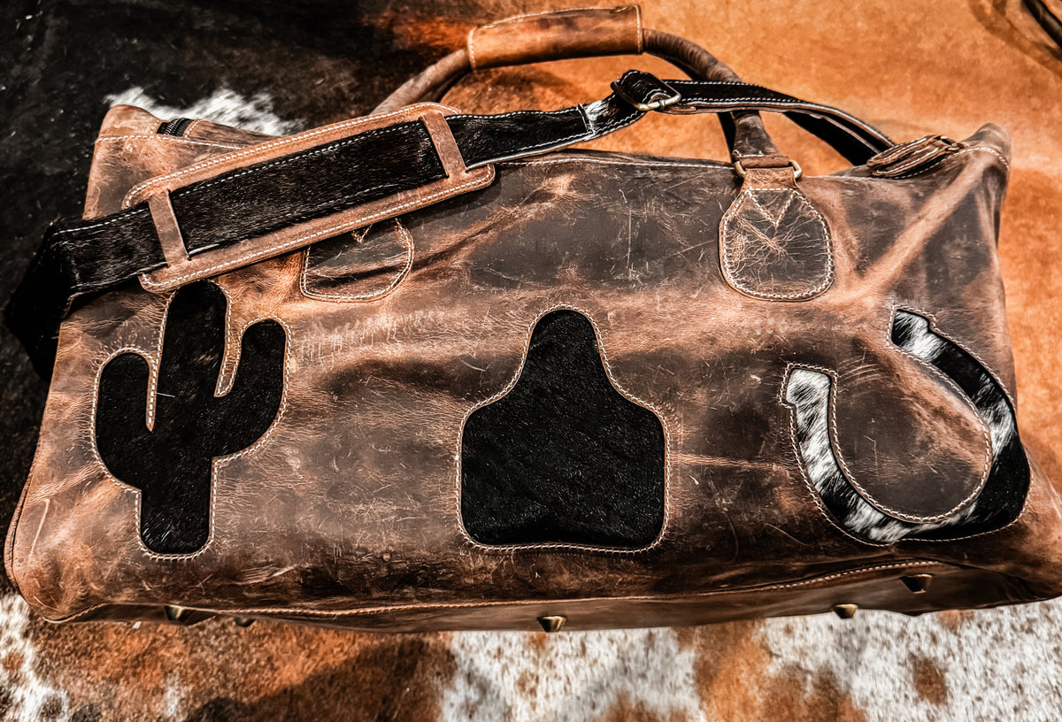 Cactus, cow tag, & horseshoe cowhide and leather duffel bag
